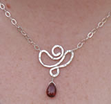 hand forged sterling lotus flower pendant with garnet briolette